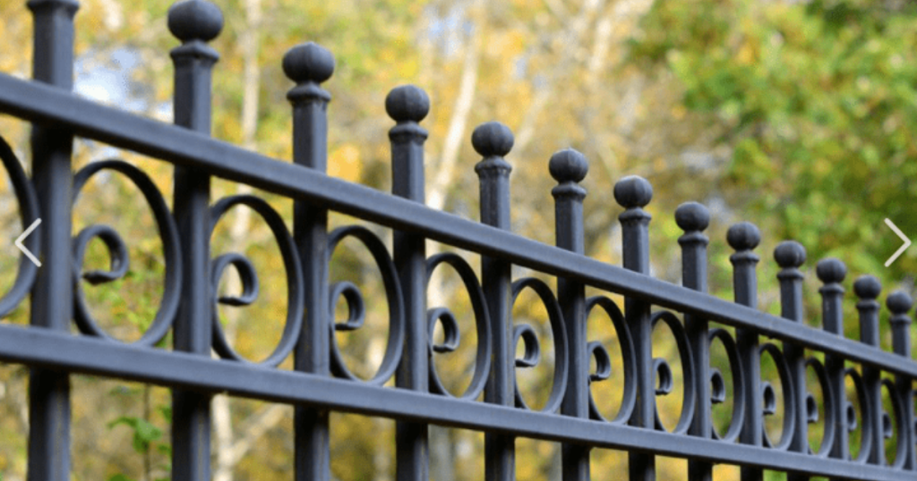 Black metal fence with decorative circular patterns.