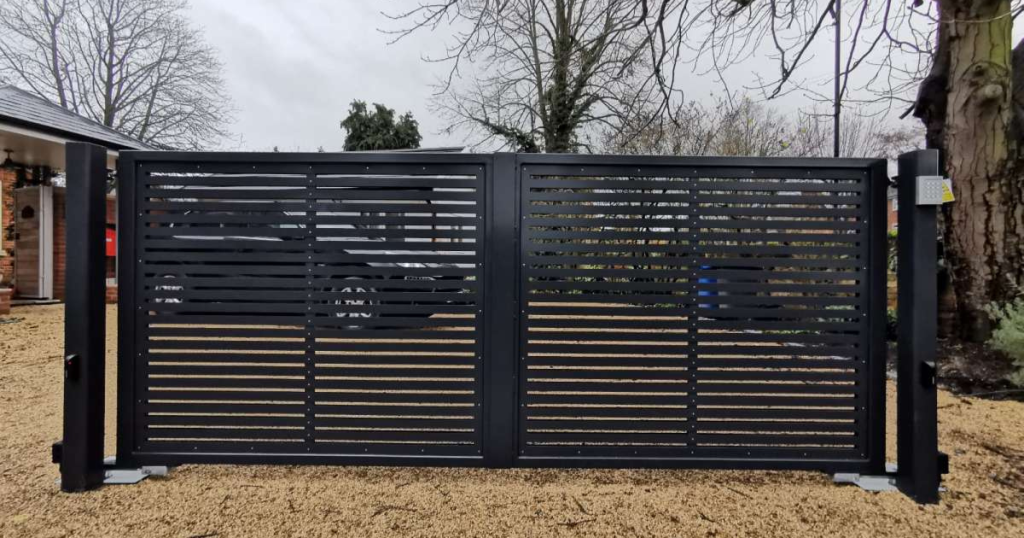 Modern black metal gate on gravel driveway